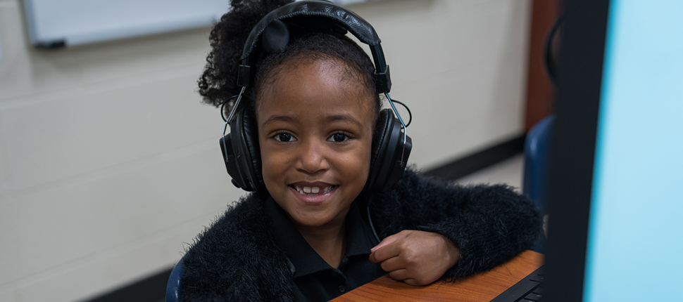 Elementary school girl with headphones smiling